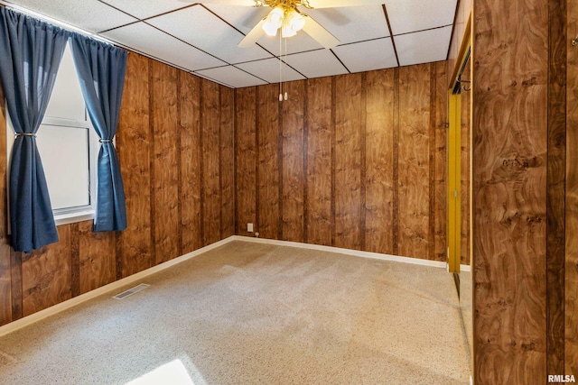 925 Payson Ave, Quincy, IL 62301 - spare room featuring wood walls, a drop ceiling, ceiling fan, and carpet