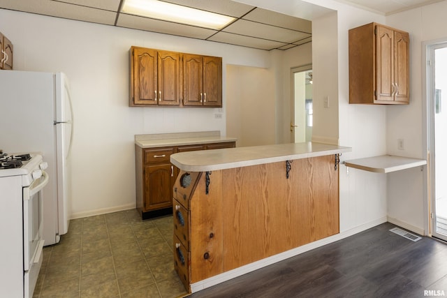 925 Payson Ave, Quincy, IL 62301 - kitchen with white gas range, a peninsula, light countertops, brown cabinets, and a drop ceiling