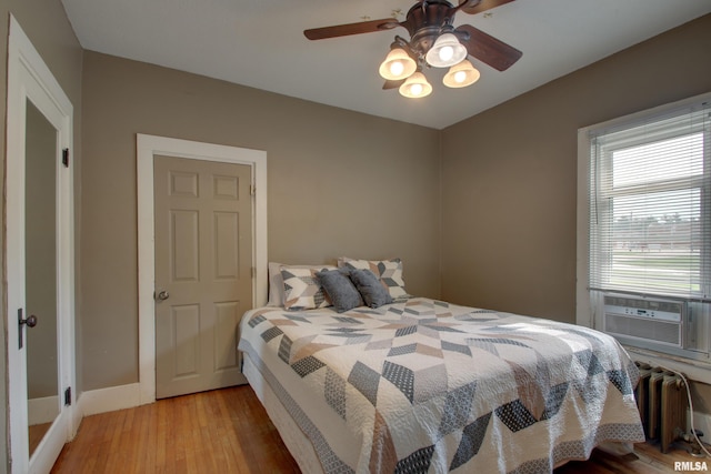 1940 Mulholland St, Nauvoo, IL 62354 - bedroom featuring radiator heating unit, light wood finished floors, cooling unit, and a ceiling fan
