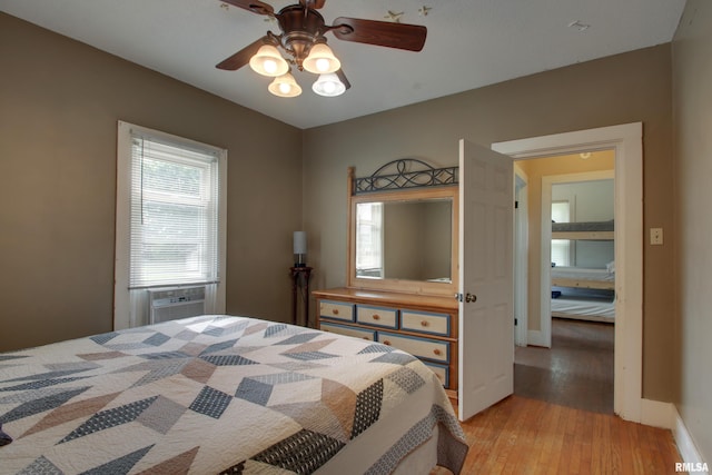 1940 Mulholland St, Nauvoo, IL 62354 - bedroom with light wood-style flooring, cooling unit, and a ceiling fan