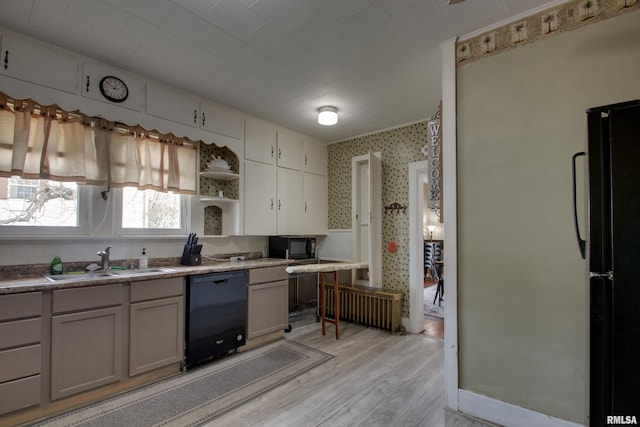 1940 Mulholland St, Nauvoo, IL 62354 - kitchen with black appliances, light wood finished floors, open shelves, and radiator heating unit