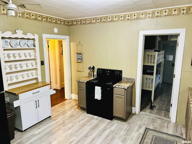 1940 Mulholland St, Nauvoo, IL 62354 - kitchen featuring black range with electric stovetop, light wood-style floors, ceiling fan, and wooden counters
