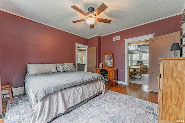 114 N Spring St, Mount Pulaski, IL 62548 - bedroom featuring wood finished floors, a chandelier, ceiling fan, and crown molding
