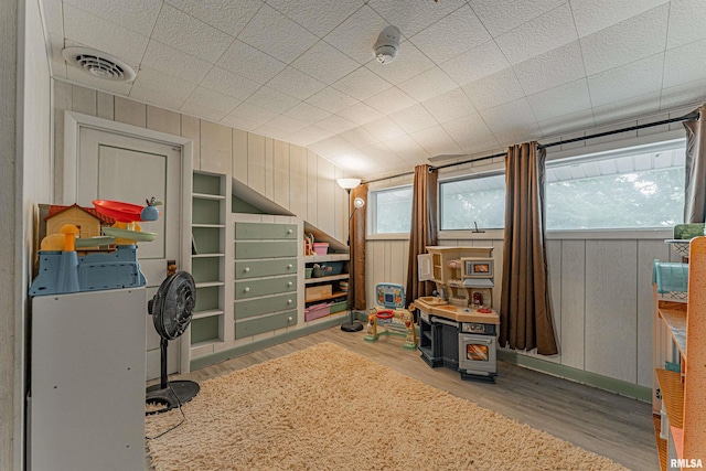 114 N Spring St, Mount Pulaski, IL 62548 - office area with wood finished floors, vaulted ceiling, healthy amount of natural light, and wood walls