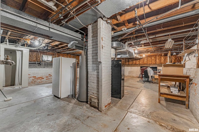 114 N Spring St, Mount Pulaski, IL 62548 - unfinished below grade area featuring water heater and brick wall