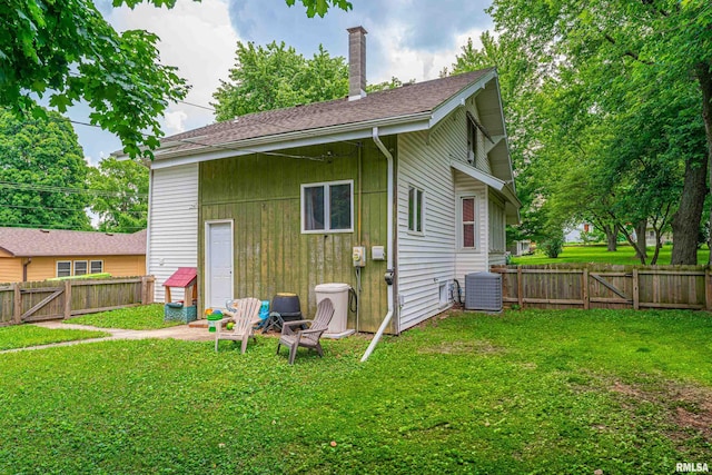 114 N Spring St, Mount Pulaski, IL 62548 - rear view of house featuring a fenced backyard, a chimney, a shingled roof, and a gate