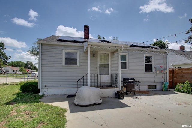 1421 N 13th St, Quincy, IL 62301 - rear view of house featuring a chimney, a patio area, and solar panels