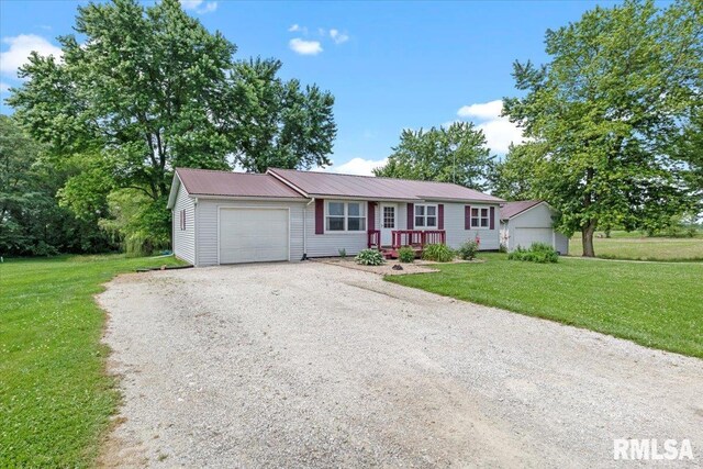 19581 Finney Rd, Girard, IL 62640 - ranch-style house featuring an attached garage, gravel driveway, a front lawn, and a metal roof