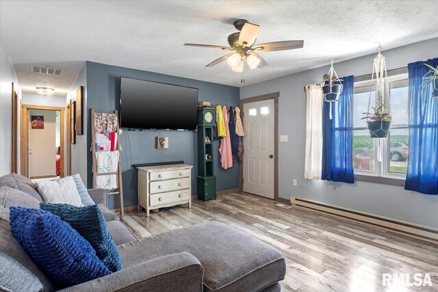 19581 Finney Rd, Girard, IL 62640 - living area with a baseboard radiator, wood finished floors, and a ceiling fan