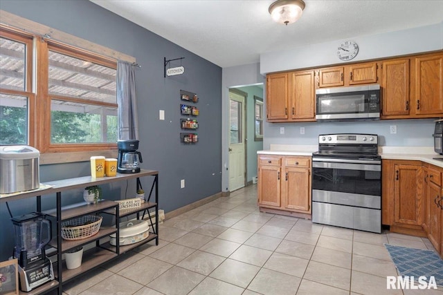 19581 Finney Rd, Girard, IL 62640 - kitchen with appliances with stainless steel finishes, light countertops, and light tile patterned floors