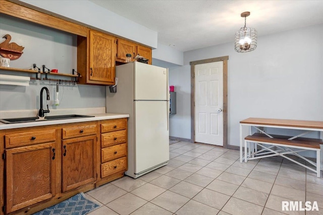 19581 Finney Rd, Girard, IL 62640 - kitchen featuring freestanding refrigerator, brown cabinetry, light countertops, and hanging light fixtures