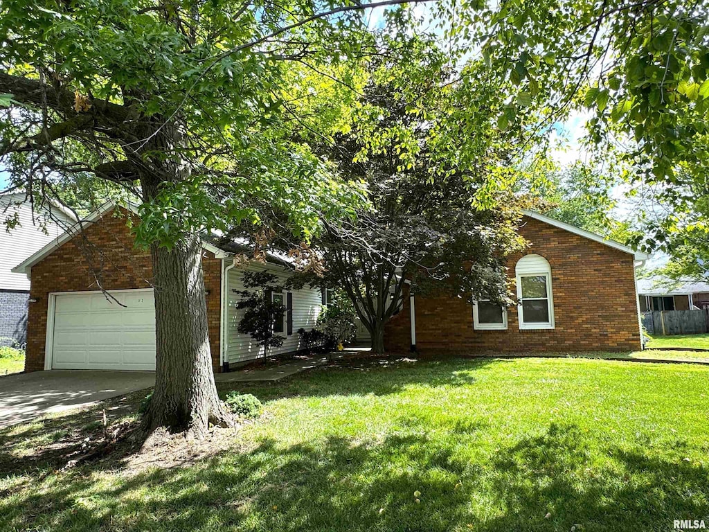 312 Astoria Rd, Springfield, IL 62704 - view of property hidden behind natural elements with brick siding, a front lawn, concrete driveway, and an attached garage