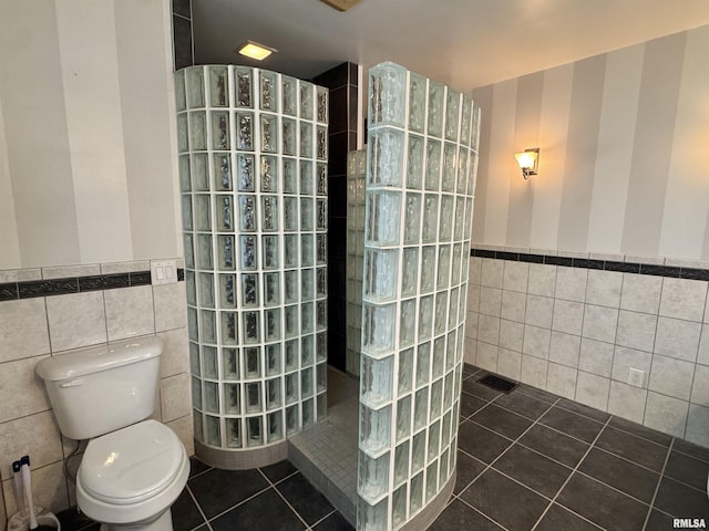 814 N Prairie St, Galesburg, IL 61401 - bathroom featuring tile walls, tile patterned flooring, a wainscoted wall, and a walk in shower