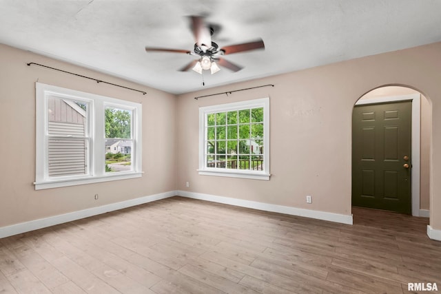 2535 S 8th St, Springfield, IL 62703 - empty room with plenty of natural light, a ceiling fan, arched walkways, and wood finished floors