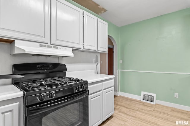 2535 S 8th St, Springfield, IL 62703 - kitchen featuring black gas stove, under cabinet range hood, arched walkways, white cabinetry, and light countertops