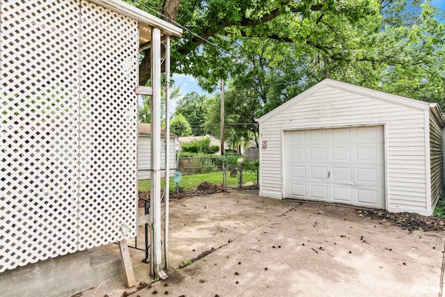 2535 S 8th St, Springfield, IL 62703 - detached garage featuring concrete driveway and view of wooded area