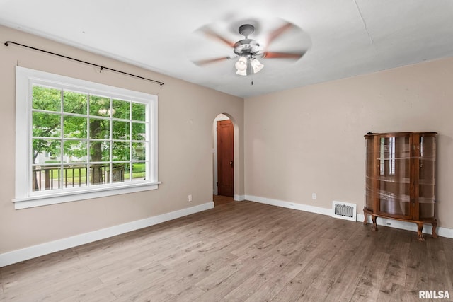 2535 S 8th St, Springfield, IL 62703 - spare room featuring arched walkways, a ceiling fan, and wood finished floors