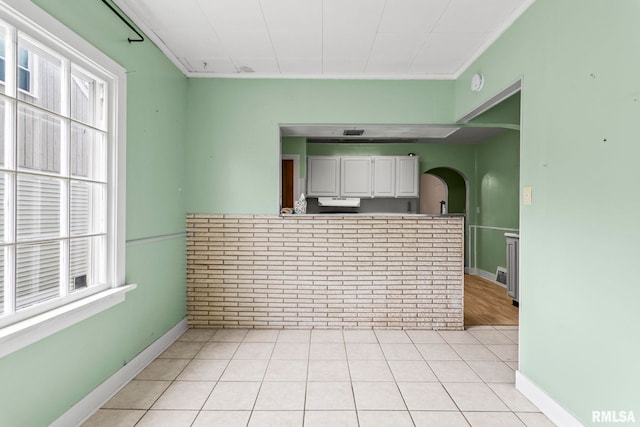 2535 S 8th St, Springfield, IL 62703 - kitchen with arched walkways, healthy amount of natural light, light tile patterned flooring, white cabinetry, and ornamental molding