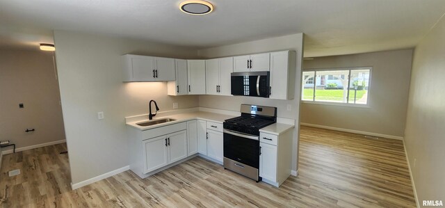 2217 Ramsey Ave, Springfield, IL 62702 - kitchen with appliances with stainless steel finishes, light wood-style floors, light countertops, and white cabinets