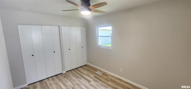 2217 Ramsey Ave, Springfield, IL 62702 - unfurnished bedroom with multiple closets, light wood-style flooring, and ceiling fan