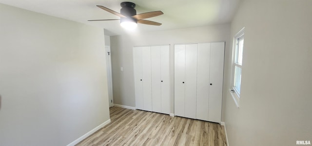 2217 Ramsey Ave, Springfield, IL 62702 - unfurnished bedroom featuring light wood-style floors, two closets, and a ceiling fan