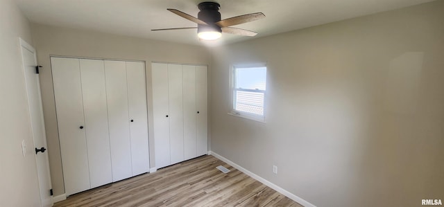 2217 Ramsey Ave, Springfield, IL 62702 - unfurnished bedroom with multiple closets, light wood-style flooring, and a ceiling fan