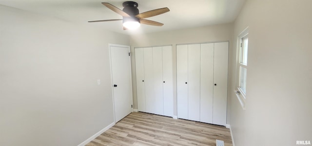 2217 Ramsey Ave, Springfield, IL 62702 - unfurnished bedroom with multiple closets, light wood-style floors, and ceiling fan