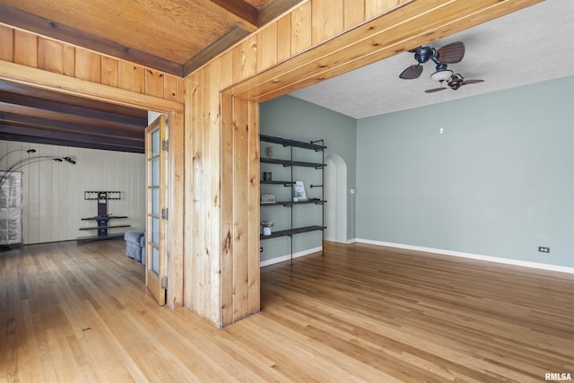 508 N Washington St, Mount Pulaski, IL 62548 - empty room with wood finished floors, a ceiling fan, arched walkways, wood walls, and beam ceiling