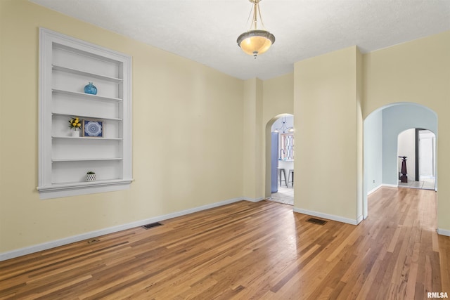 508 N Washington St, Mount Pulaski, IL 62548 - unfurnished room with arched walkways, light wood-type flooring, and built in features