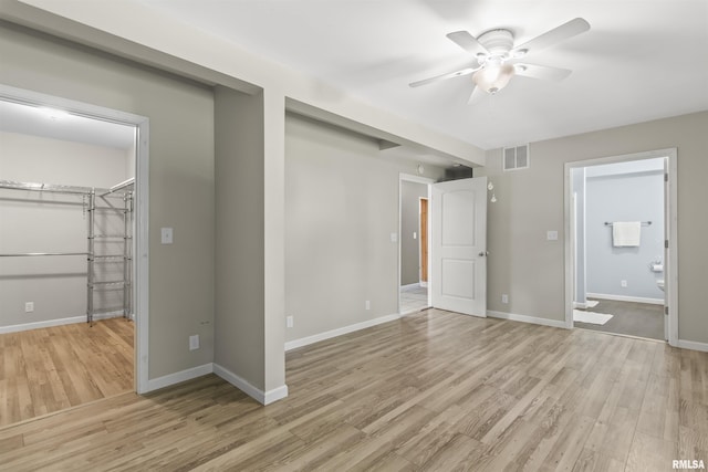 508 N Washington St, Mount Pulaski, IL 62548 - unfurnished bedroom featuring light wood-style floors, ensuite bath, a closet, and a spacious closet