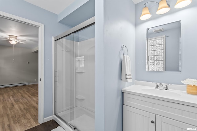 508 N Washington St, Mount Pulaski, IL 62548 - full bathroom featuring a shower stall, a baseboard radiator, wood finished floors, ceiling fan, and vanity