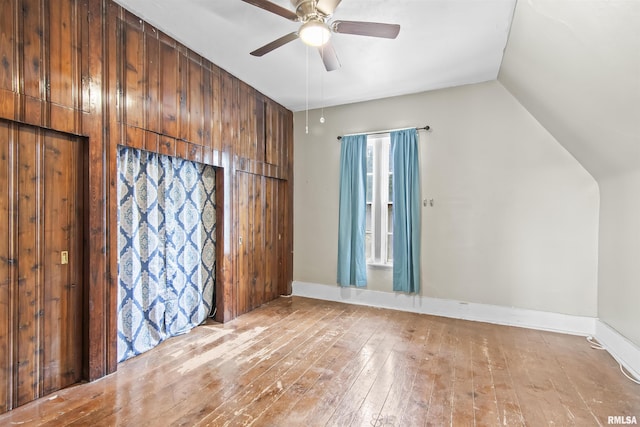 508 N Washington St, Mount Pulaski, IL 62548 - unfurnished bedroom with hardwood / wood-style floors, lofted ceiling, a ceiling fan, and wooden walls