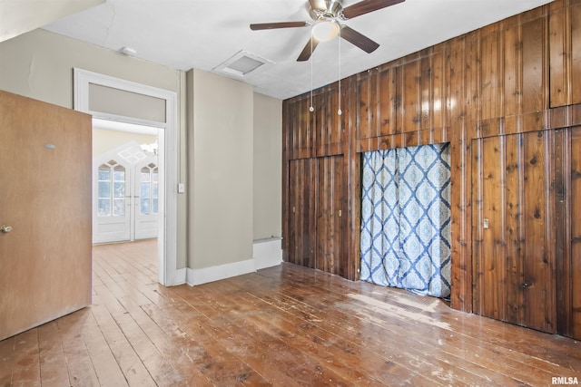 508 N Washington St, Mount Pulaski, IL 62548 - spare room with hardwood / wood-style flooring, attic access, and wood walls