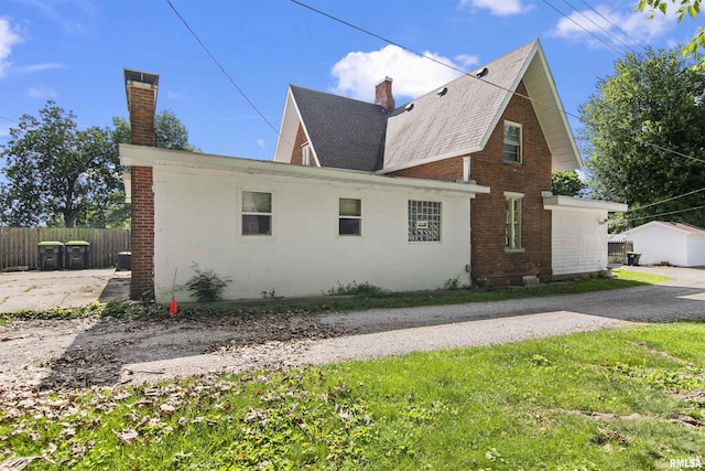 508 N Washington St, Mount Pulaski, IL 62548 - view of side of home featuring a chimney, a shingled roof, and brick siding