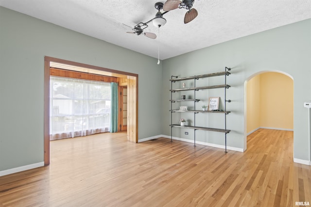 508 N Washington St, Mount Pulaski, IL 62548 - spare room featuring arched walkways, wood finished floors, a textured ceiling, and a ceiling fan