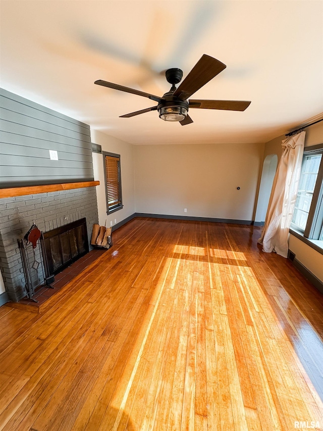 1011 S 20th St, Quincy, IL 62301 - unfurnished living room with light wood-type flooring, a brick fireplace, and ceiling fan