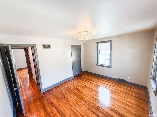 1011 S 20th St, Quincy, IL 62301 - spare room featuring a chandelier and hardwood / wood-style floors