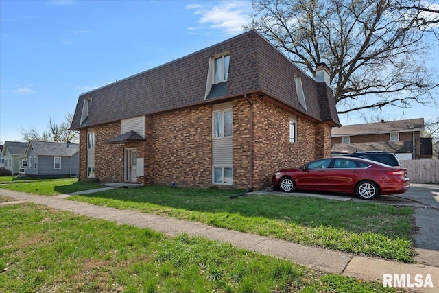 102 W Scarritt St, Springfield, IL 62704 - view of property exterior with brick siding, mansard roof, roof with shingles, a yard, and a chimney