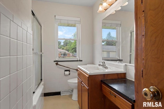 1640 W Glenn Ave, Springfield, IL 62704 - full bathroom featuring tile walls, vanity, and bath / shower combo with glass door