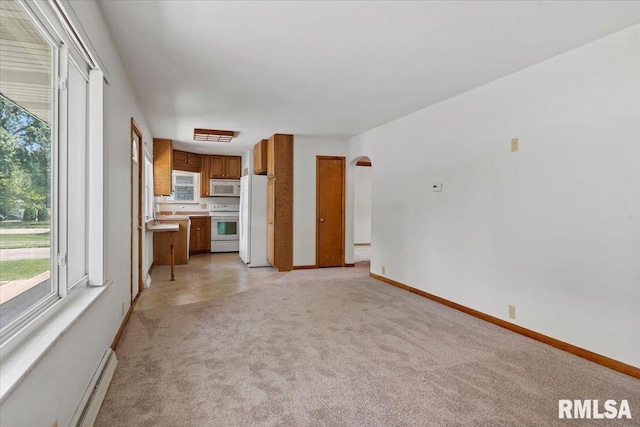 1640 W Glenn Ave, Springfield, IL 62704 - unfurnished living room with light carpet, a baseboard radiator, and arched walkways