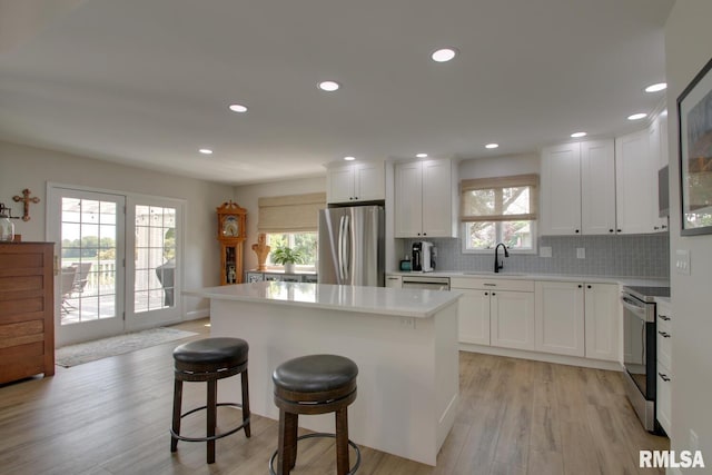 1521 Silverthorne Dr, Quincy, IL 62305 - kitchen with stainless steel appliances, a center island, light wood-style floors, plenty of natural light, and recessed lighting