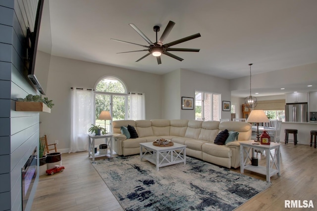 1521 Silverthorne Dr, Quincy, IL 62305 - living area featuring plenty of natural light, a ceiling fan, a glass covered fireplace, and light wood finished floors