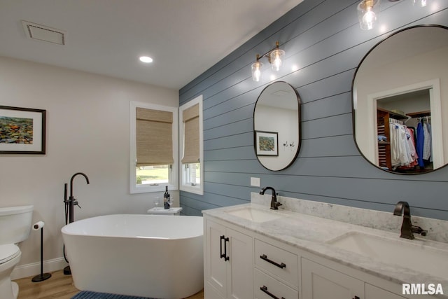 1521 Silverthorne Dr, Quincy, IL 62305 - full bath with a freestanding tub, double vanity, wood finished floors, wooden walls, and a spacious closet