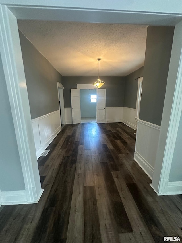 1249 W Urban Ave, Springfield, IL 32704 - unfurnished dining area featuring a wainscoted wall, dark wood-style flooring, and a textured ceiling