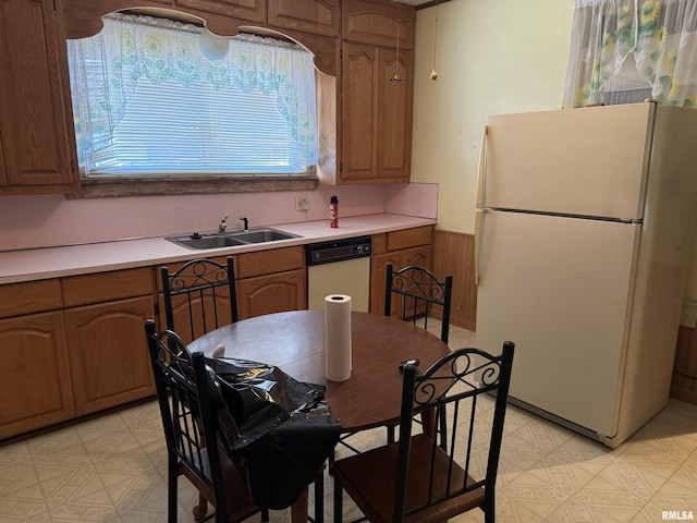 222 N Broadway St, Havana, IL 62644 - kitchen with white appliances, light floors, light countertops, wainscoting, and brown cabinetry