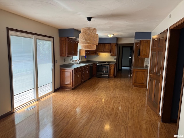 1804 Hunter Ridge Dr, Springfield, IL 62704 - kitchen with stainless steel electric range, light wood-style floors, dark countertops, and hanging light fixtures