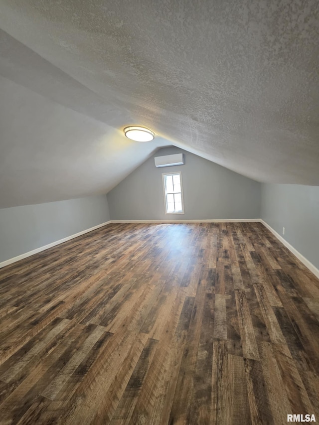 815 Washington St, Quincy, IL 62301 - bonus room with an AC wall unit, dark wood-style flooring, vaulted ceiling, and a textured ceiling
