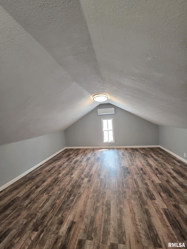 815 Washington St, Quincy, IL 62301 - additional living space with dark wood-style flooring, a textured ceiling, lofted ceiling, and an AC wall unit