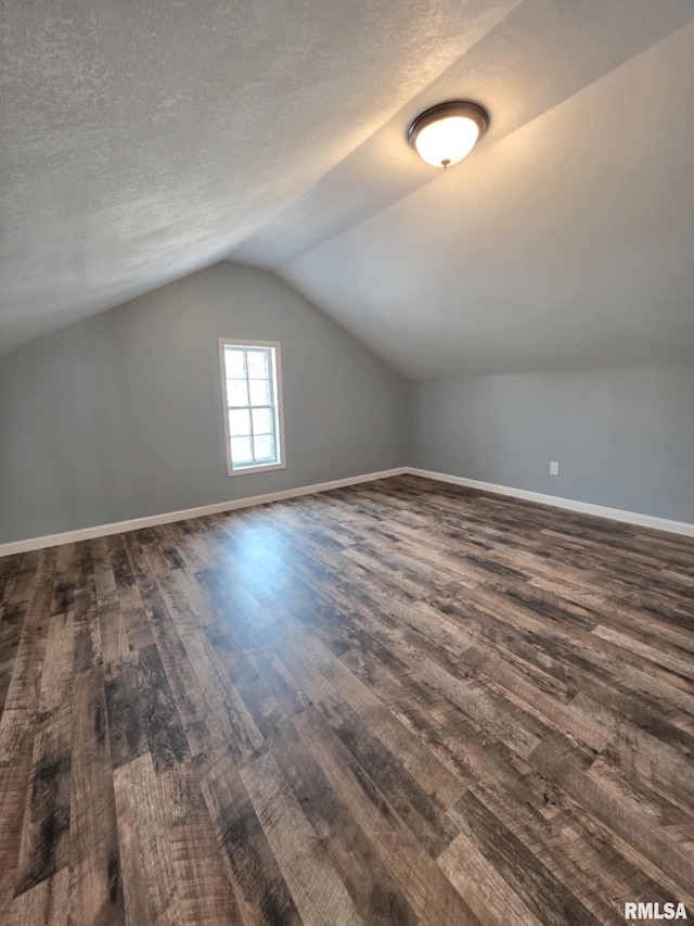 815 Washington St, Quincy, IL 62301 - additional living space featuring dark wood-style flooring, vaulted ceiling, and a textured ceiling