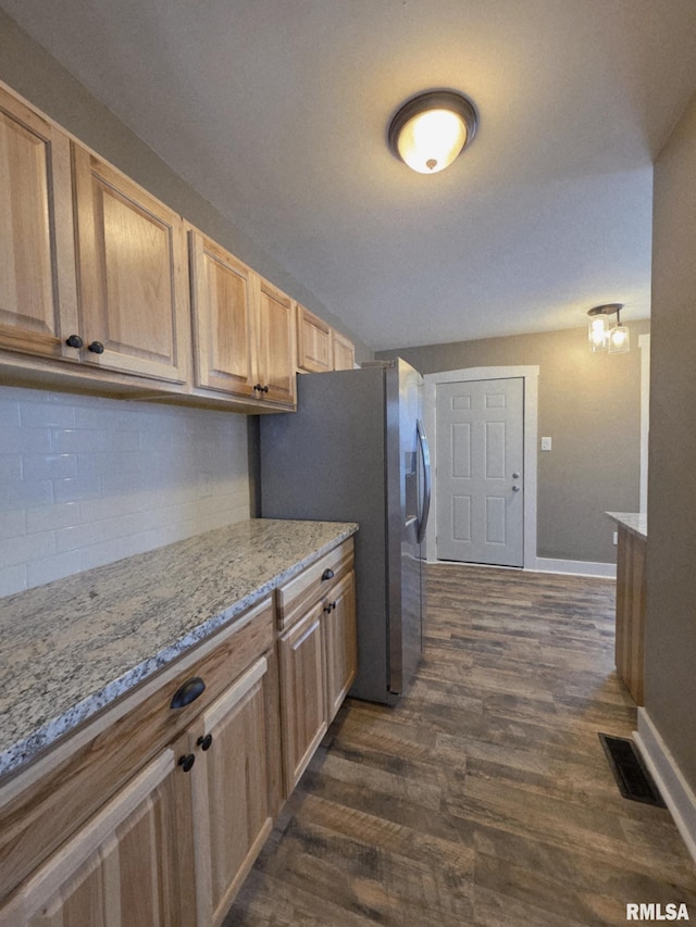 815 Washington St, Quincy, IL 62301 - kitchen featuring dark wood-style floors, stainless steel fridge, light stone counters, backsplash, and light brown cabinets
